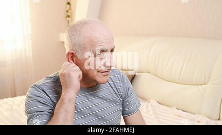 uomo anziano con dolore all'orecchio. Foto Stock