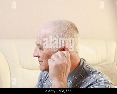 uomo anziano con dolore all'orecchio. Foto Stock