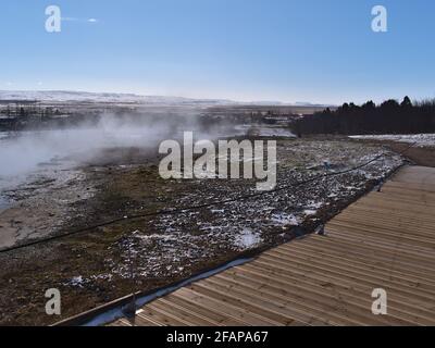 Percorso in legno che conduce attraverso la zona geotermica Geysir, Haukadalur, Islanda, parte del cerchio d'Oro, con sorgenti termali e fumarole fumanti. Foto Stock