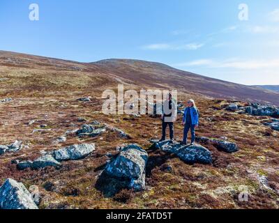 Due escursionisti sul sentiero fino a Meall Chuaich, una montagna Munro vicino a Dalwhinnie, Scozia. La cima è visibile sullo sfondo Foto Stock