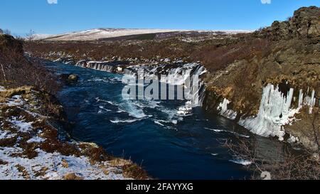 Bella vista delle famose cascate di Hraunfossar (islandese: Cascate di lava) vicino a Húsafell, nell'Islanda occidentale, nella soleggiata giornata invernale con fiume selvaggio. Foto Stock