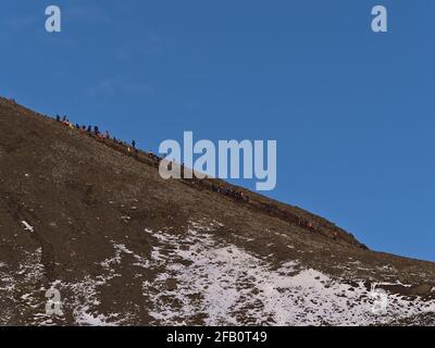 Si sale su una collina rocciosa sul sentiero escursionistico al vulcano recentemente eruttato vicino alla montagna Fagradalsfjall nella valle di Geldingadalir in Islanda. Foto Stock