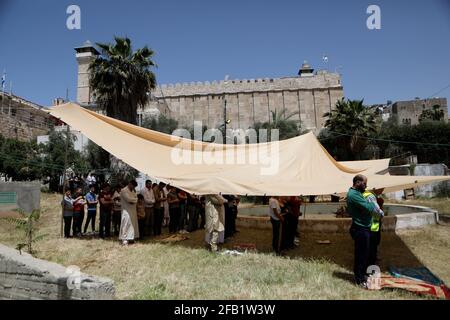 Hebron. 23 Apr 2021. La gente prega fuori della moschea di Ibrahimi durante la preghiera del secondo venerdì del mese santo di Ramadan nella città della Cisgiordania di Hebron, 23 aprile 2021. Credit: Mamoun Wazwaz/Xinhua/Alamy Live News Foto Stock