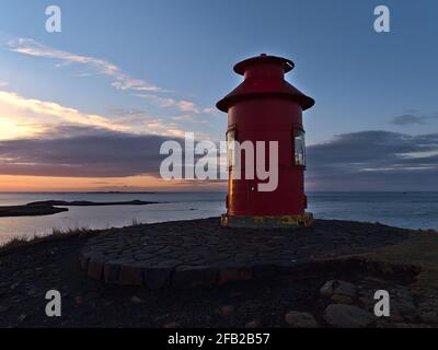 Splendida vista al tramonto del faro rosso di Súgandisey su un'isola di Stykkishólmur, penisola di Snæfellsnes, Islanda occidentale sulla costa. Foto Stock