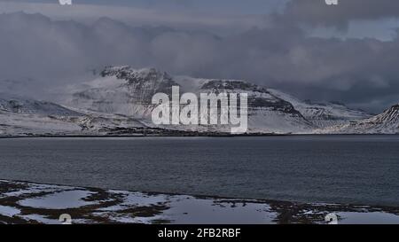 Bella vista del piccolo villaggio Grundarfjörður situato sulla costa settentrionale della penisola di Snæfellsnes, Islanda occidentale nella stagione invernale con le montagne. Foto Stock
