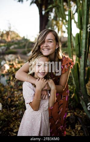 Le sorelle si abbracciano nel Giardino del deserto a San Diego Foto Stock