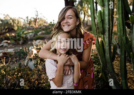 Le sorelle si abbracciano nel Giardino del deserto a San Diego Foto Stock