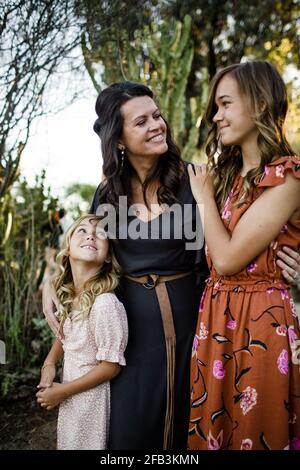 Madre che abbraccia le Figlie nel Giardino del deserto a San Diego Foto Stock