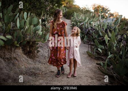 Sorelle camminando mano in mano attraverso il Giardino del deserto a San Diego Foto Stock