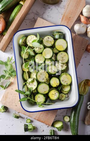 Zucchine verdi fresche a fette in una teglia in ceramica. Vista dall'alto. Foto Stock