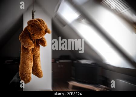 Un orsacchiotto appeso in un cappio nella soffitta camera Foto Stock