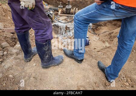 un uomo che lavora in uniforme è impegnato nella riparazione del tubo del gas, la riparazione dell'apparecchiatura con gli attrezzi, la riparazione delle comunicazioni del ferro gasman, migliorandone Foto Stock