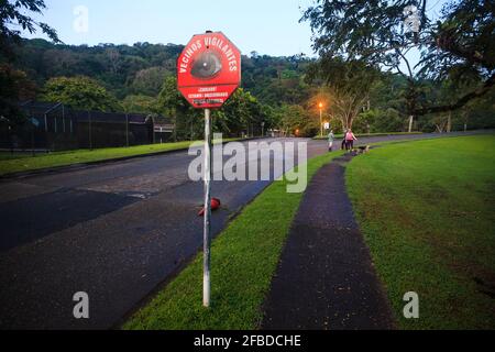 Cartello stradale che dice 'vercinos vigilantes' (vicini vigili) nella città di Gamboa, provincia di Colon, Repubblica di Panama, America Centrale. Foto Stock