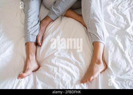 Coppia che indossa pigiami mentre si sdraia sul letto Foto Stock