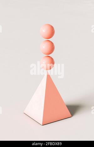 Piramide astratta rosa con tre sfere che si bilanciano in cima sfondo color crema Foto Stock