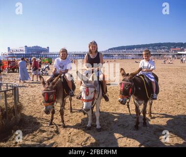 Bambini giostre di asino sulla spiaggia, Weston-Super-Mare, Somerset, Inghilterra, Regno Unito Foto Stock