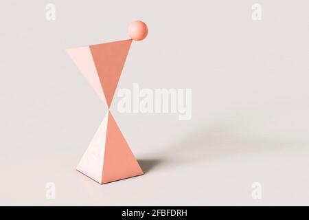 Piramidi astratte rosa con una sfera in equilibrio sulla parte superiore contro sfondo color crema Foto Stock