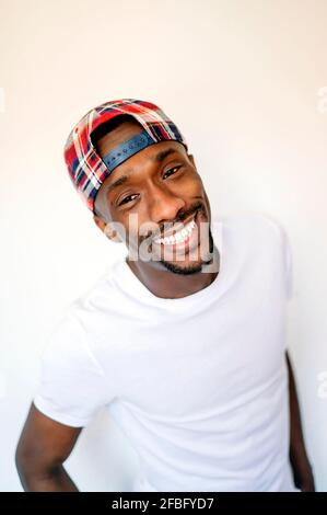 Giovane sorridente con cappuccio su sfondo bianco Foto Stock