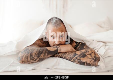 Uomo maturo con occhi chiusi in piedi da fiore giallo Foto Stock