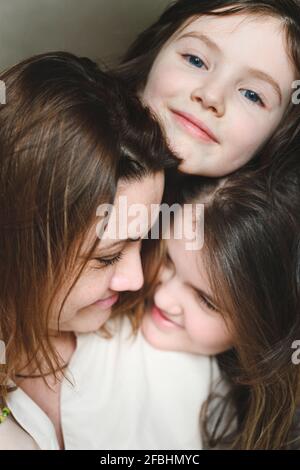 Sorridente madre e figlie insieme a casa Foto Stock