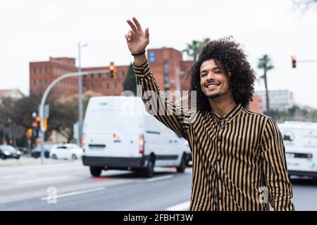 Un giovane sorridente che si accavalca su strada in città Foto Stock