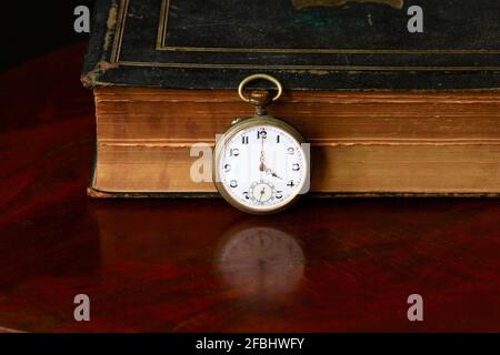 Studio di vecchio libro e orologio da tasca antico Foto Stock