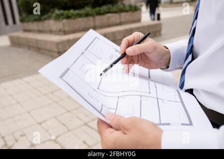Architetto maschile maturo che lavora su Blueprint Foto Stock