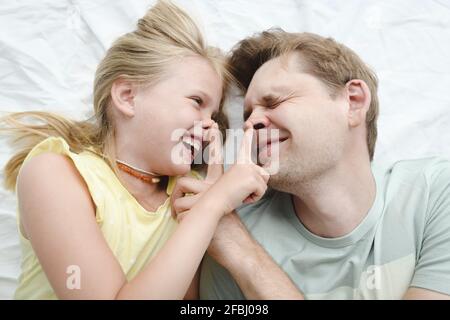 Padre e figlia saltando in camera da letto Foto Stock