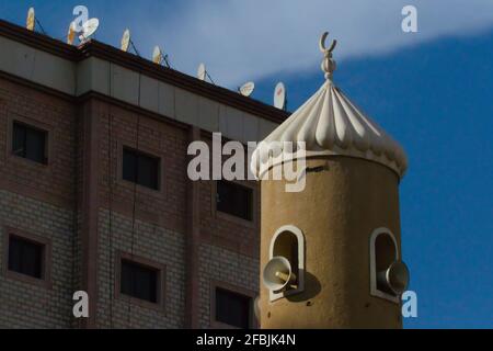 Kuwait City, Kuwait - 8 aprile 2021: Minareto di moschea con piatti satellitari sulla parte superiore dell'edificio Foto Stock