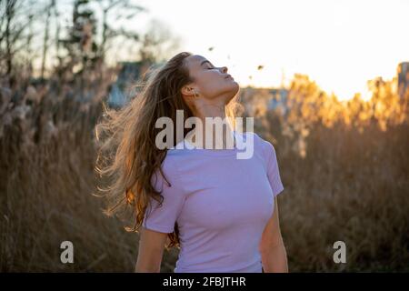 Donna in abito viola in piedi in natura Foto Stock