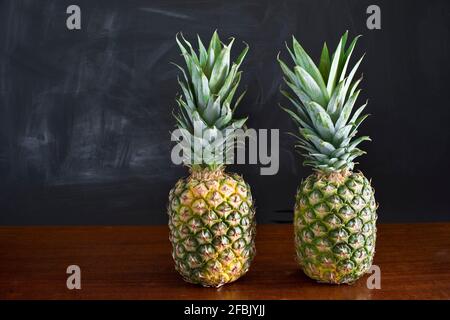Ancora vita con due ananas di fronte al muro scuro Foto Stock