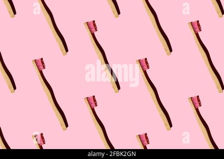 Modello generato digitalmente con spazzolini da denti di bambù su sfondo rosa Foto Stock