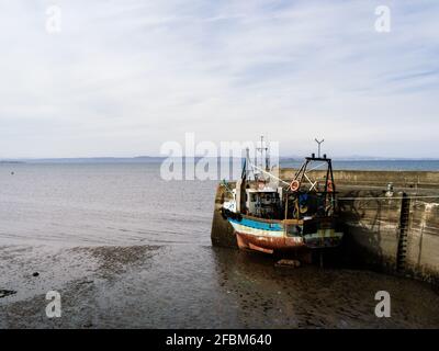 Il peschereccio da traino di gamberi si è allacciato all'ingresso del porto a bassa marea a Fisherrow, vicino a Edimburgo. Foto Stock