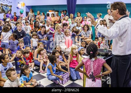 Miami Florida,DAVIE Young at Art Children's Museum,Festival of the Arts magic show,audience ragazzi ragazze mago fare trucco, Foto Stock