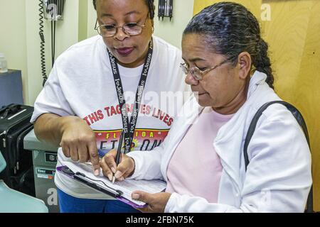 Miami Beach Florida, Community Health Center, Black woman female women che prende intervista sondaggio, screening gratuito che completa il questionario Foto Stock