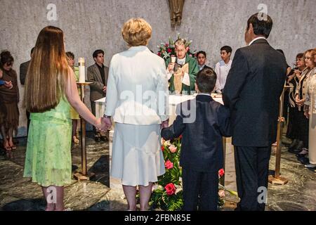 Miami Florida,Hialeah Immacolata Concezione Chiesa cattolica,congregazione ispanica altare servizio prete famiglie genitori figli tenere mani, pregare Foto Stock