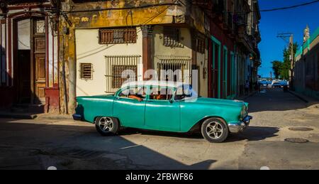 L'Avana, Cuba, luglio 2019, vista di una vecchia auto verde classica Chevrolet con passeggeri che attraversano un incrocio Foto Stock