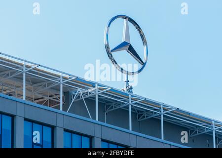 Logo Mercedes-Benz a tre punte sulla parte superiore di un edificio Foto Stock