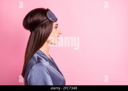 Foto ritratto profilo di donna sorridente guardando spazio vuoto isolato su sfondo color rosa pastello Foto Stock