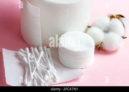 Tamponi e bastoncini bianchi in morbido cotone per l'igiene e la salute su sfondo rosa chiaro. Foto Stock