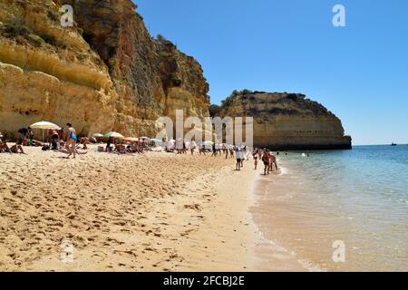 Le persone che si godono la spiaggia di Praia da Marinha, spiaggia di Marinha in Algarve Portogallo in estate, con splendide viste sul mare e sulle montagne Foto Stock