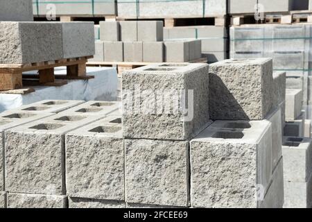 Pila di cemento cemento costruzione blocchi di scorie mattone su pallete in negozio di ferramenta con lato tessitura di pietra decorativa Foto Stock