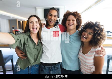 Gruppo vario di amici maschili e femminili che prendono selfie a. bar Foto Stock