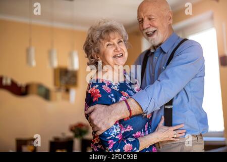 Felice coppia senior ballare insieme a casa Foto Stock