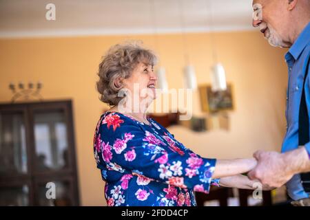 Felice coppia senior ballare insieme a casa Foto Stock
