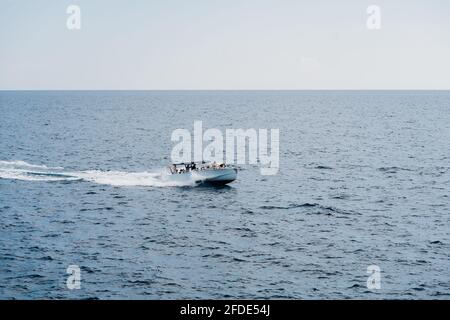 Yacht a motore con turisti a bordo vele in alto mari Foto Stock