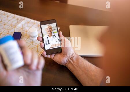Primo piano di una donna anziana che consulta con il suo medico online sul suo telefono Foto Stock