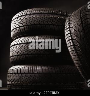 primo piano di quattro pneumatici contro il nero Foto Stock
