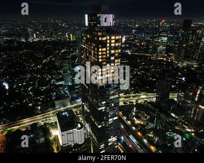 Spettacolare skyline notturno di una grande città moderna di notte. Giacarta, Indonesia. Vista aerea su autostrade e grattacieli con nube di rumore. Giacarta, in Foto Stock