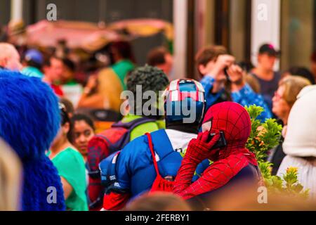 Primo piano di un uomo in un costume Spiderman che parla Al telefono a Times Square e alle persone in sfondo Foto Stock